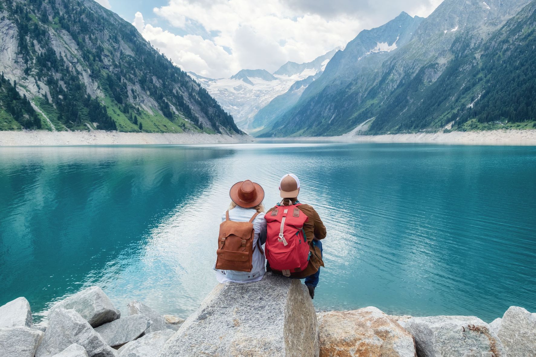 Двое человек у озера на фоне гор