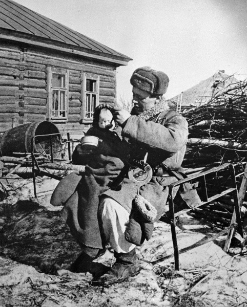 Советский солдат кормит ребёнка, у которого убили мать, 1 октября 1943